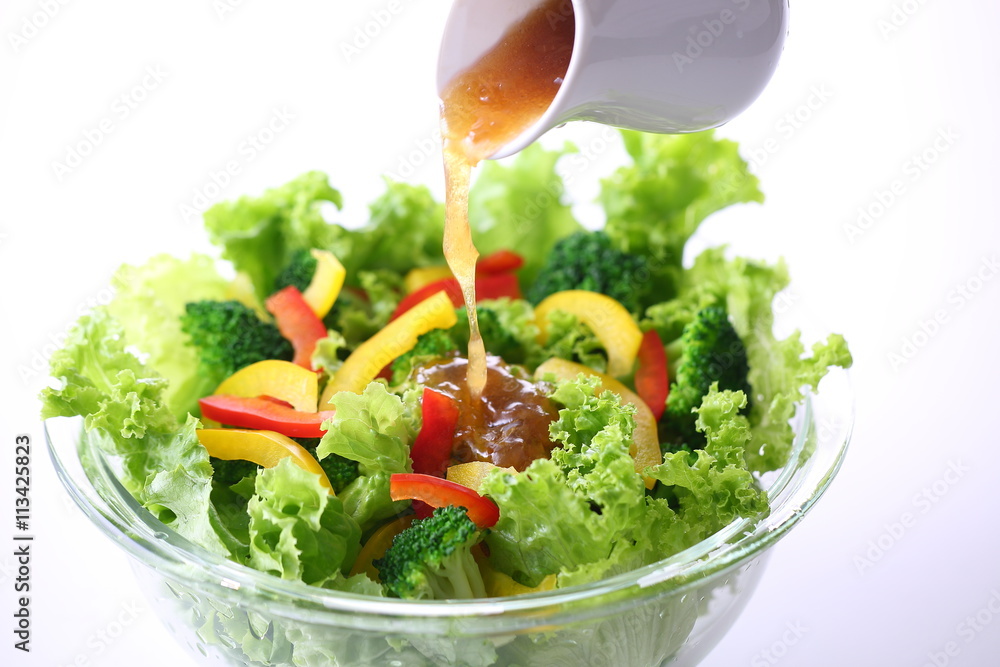 野菜サラダにドレッシングをかける