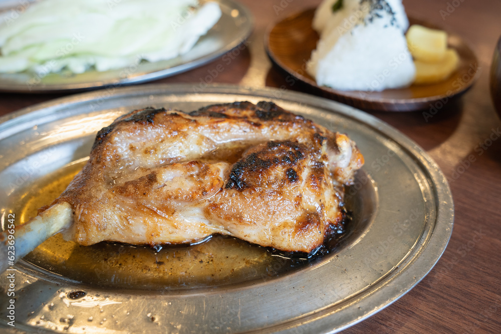 香川名物の骨付鳥。皿の油は鶏油（チーユ）といって、旨味が業種された鶏の油で仕上げるのが香川流。