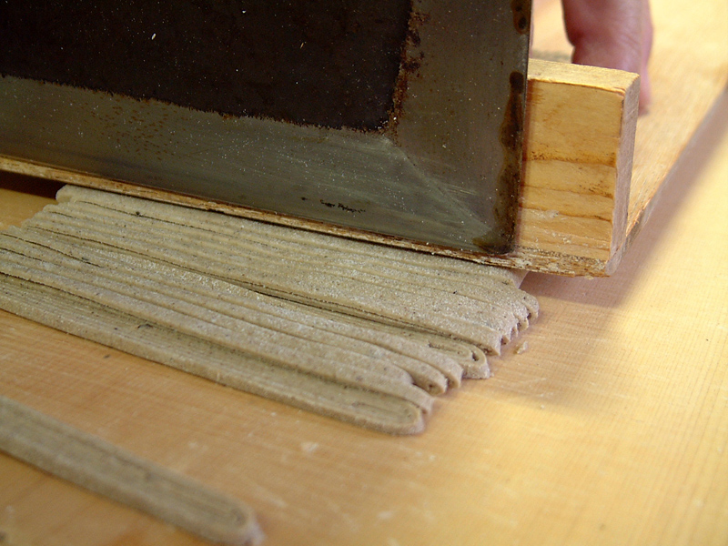 駒板を当てて「蕎麦切り包丁」で均等に蕎麦を切る。