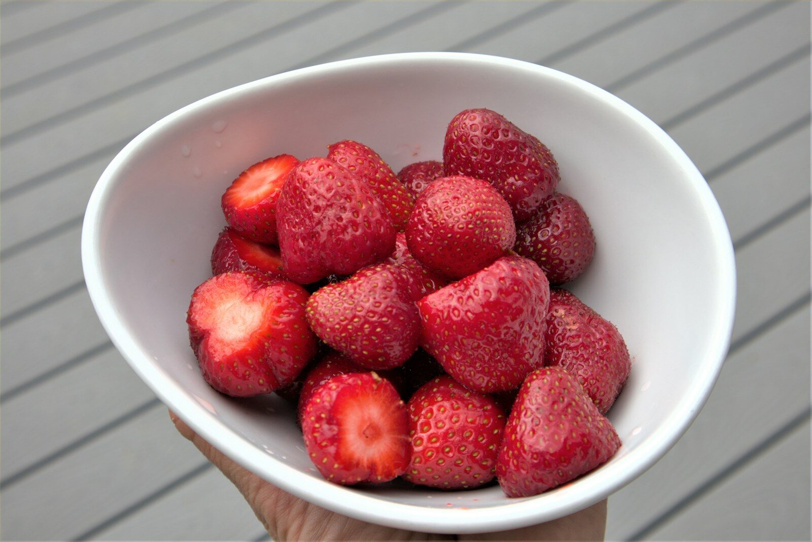 red strawberries in white ceramic bowl